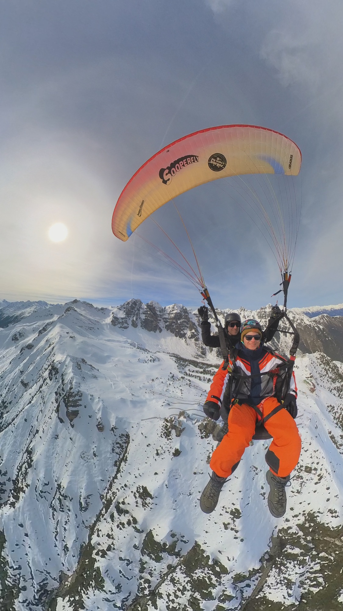 Pilot und Passagier beim Gleitschirmflug über den Alpen
